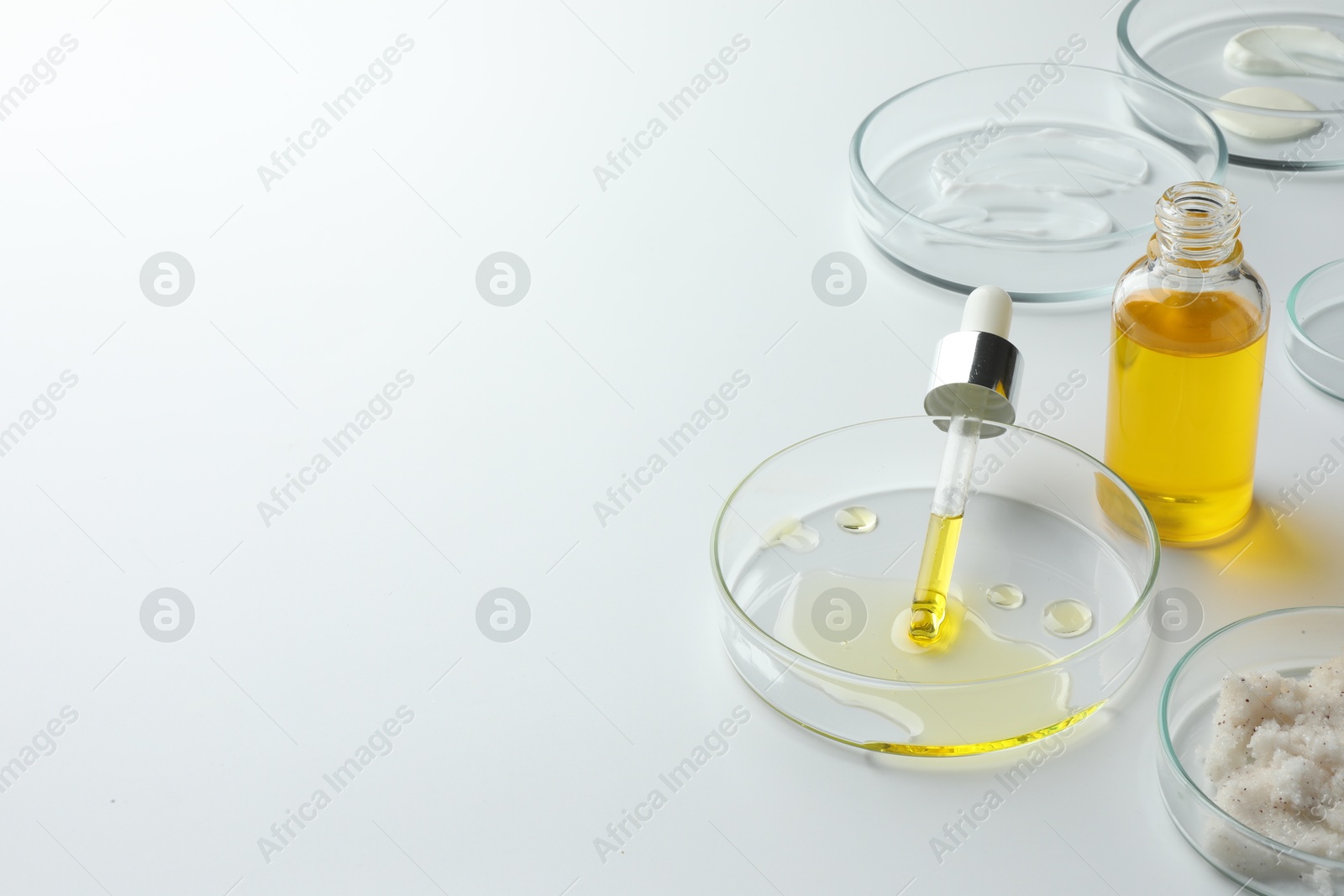 Photo of Petri dishes with different cosmetic products on white background. Space for text