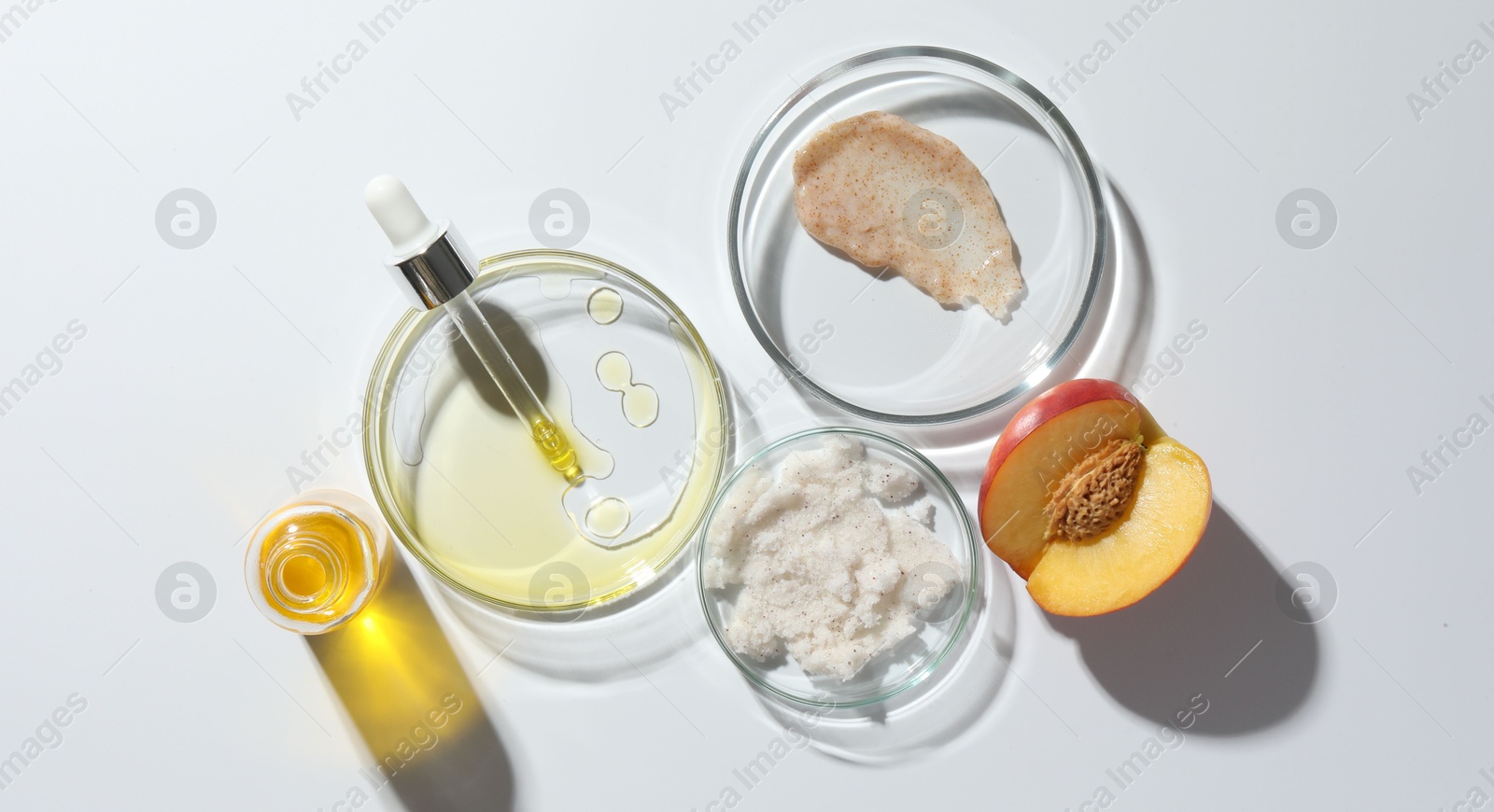 Photo of Petri dishes with different cosmetic products and peach on white background, flat lay