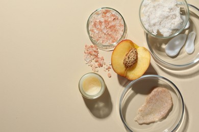 Petri dishes with different cosmetic products and peach on beige background, flat lay. Space for text