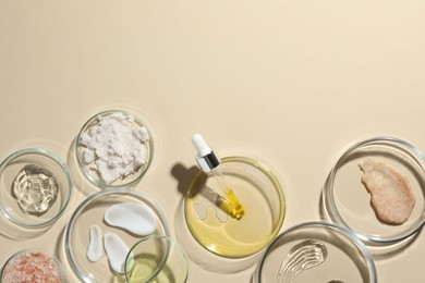 Petri dishes with different cosmetic products on beige background, flat lay. Space for text