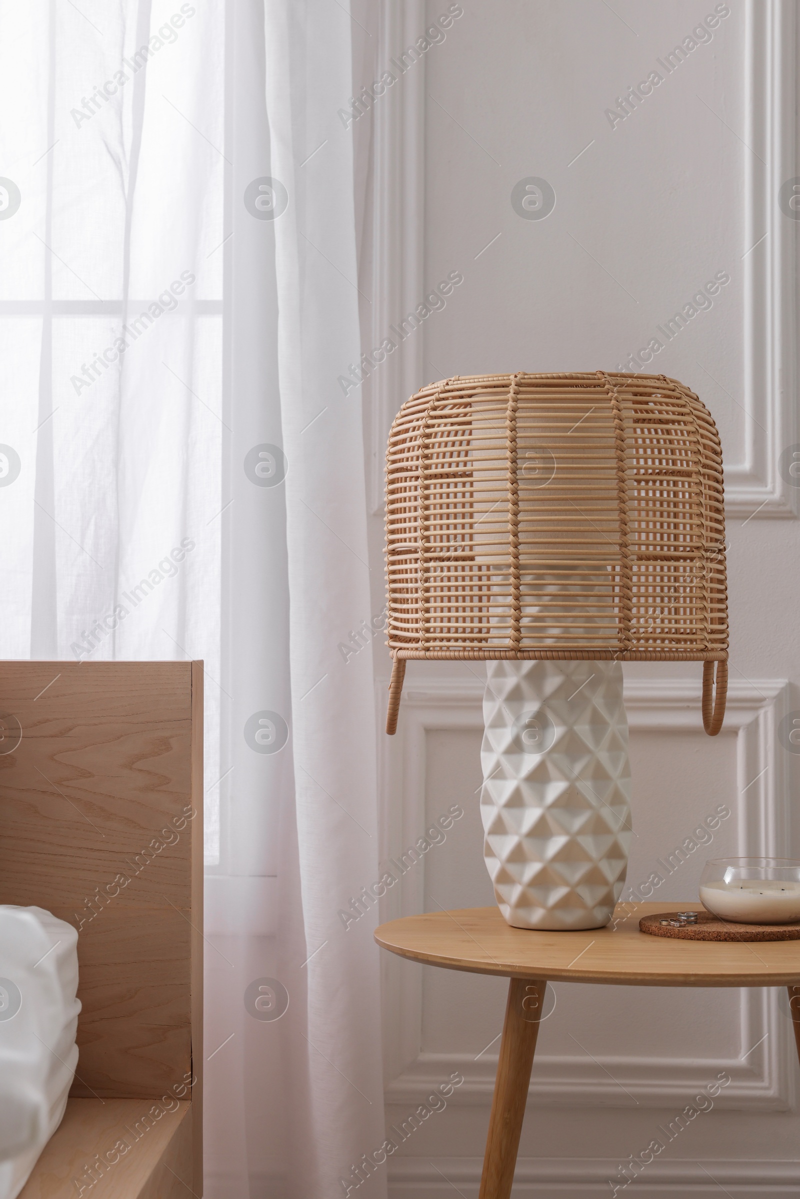 Photo of Stylish living room interior with bed, bedside table and lamp