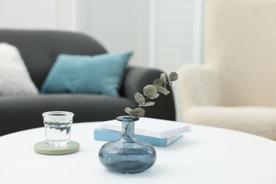 Coffee table with books and decor near sofa in living room, closeup