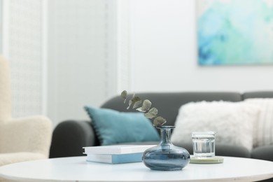 Photo of Coffee table with books and decor near sofa in living room, closeup