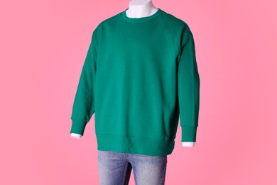 Photo of Male mannequin dressed in stylish green sweatshirt and jeans on pink background