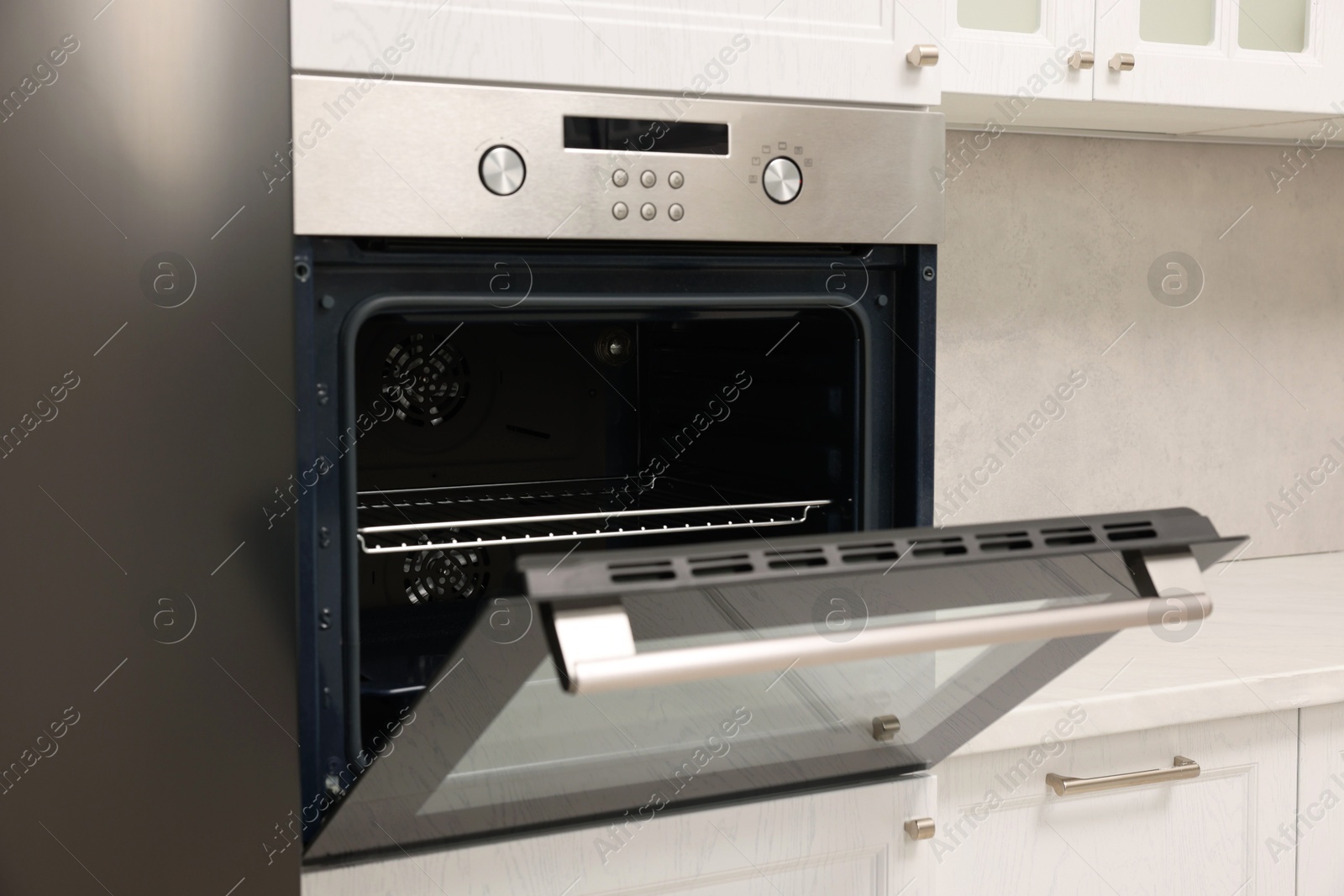 Photo of Open electric oven in kitchen. Cooking appliance