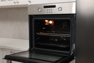 Photo of Open electric oven in kitchen. Cooking appliance