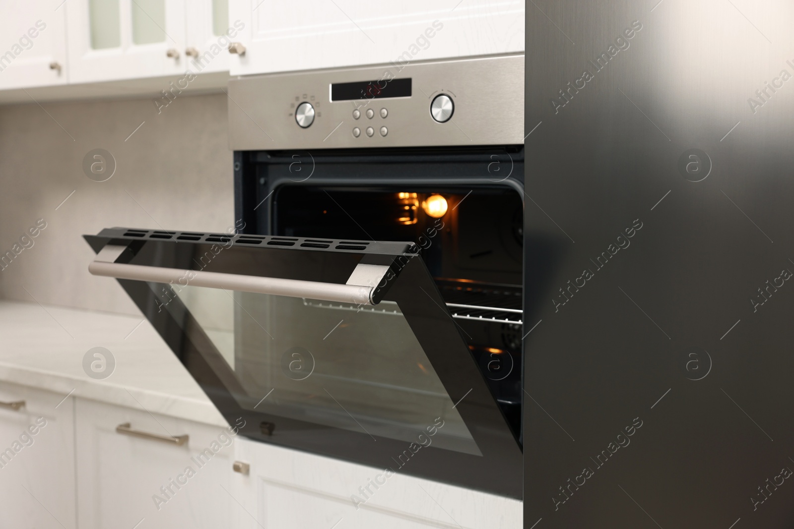 Photo of Open electric oven in kitchen. Cooking appliance