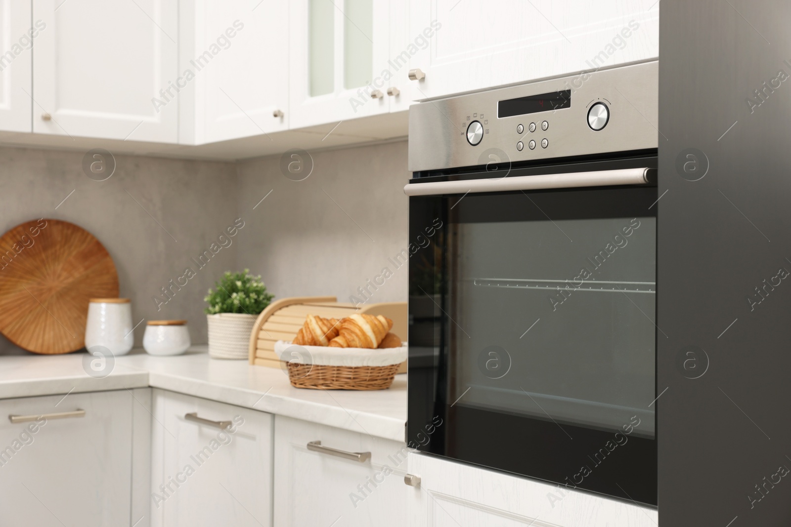 Photo of Electric oven and croissants in kitchen. Cooking appliance