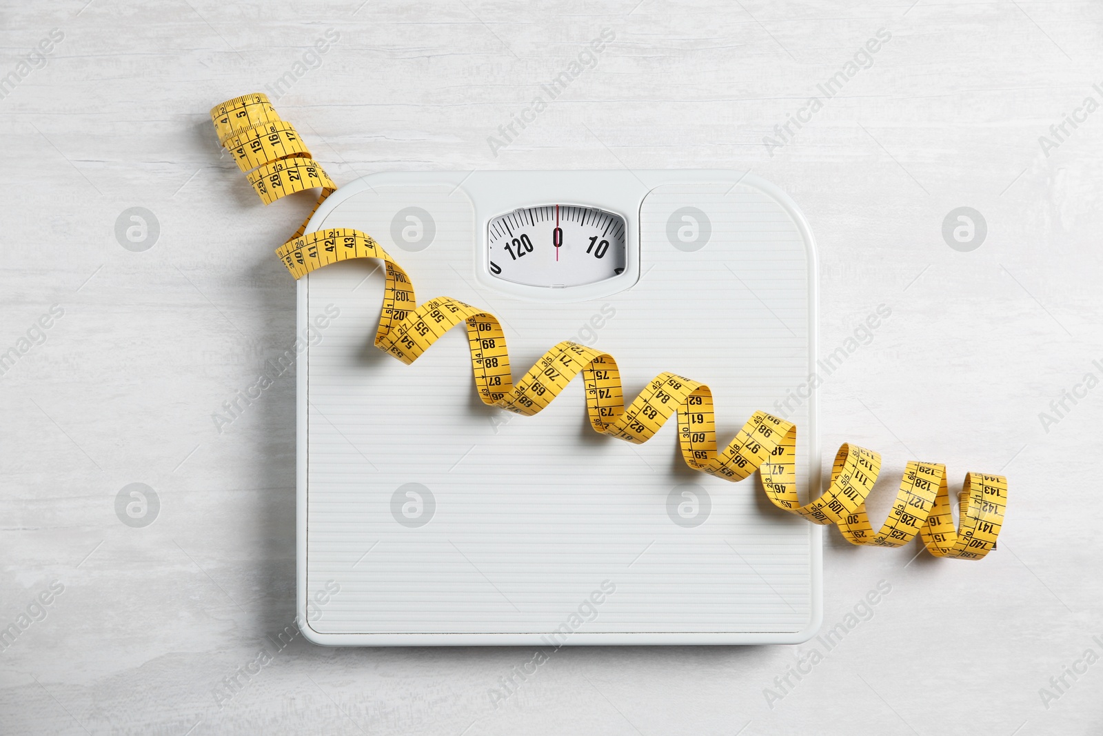 Photo of Scale and measuring tape on white wooden background, flat lay