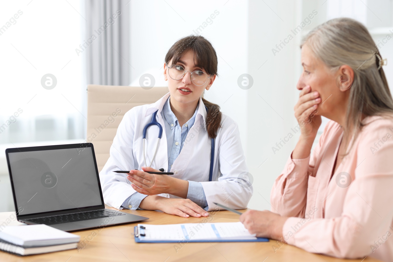 Photo of Lung disease. Doctor showing something on laptop to her patient in clinic