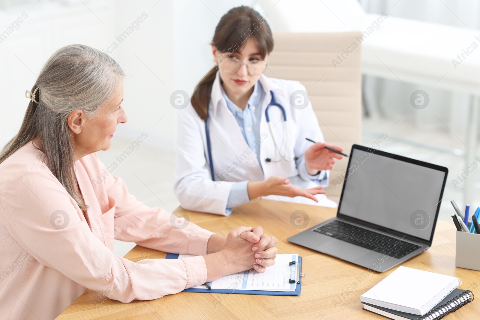 Photo of Lung disease. Doctor showing something on laptop to her patient in clinic