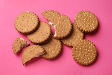 Tasty sandwich cookies on pink background, top view