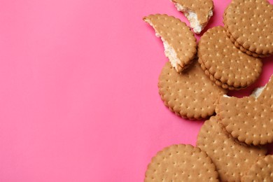 Photo of Tasty sandwich cookies on pink background, top view. Space for text