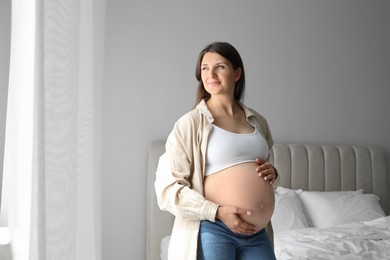 Photo of Beautiful pregnant woman at home, space for text