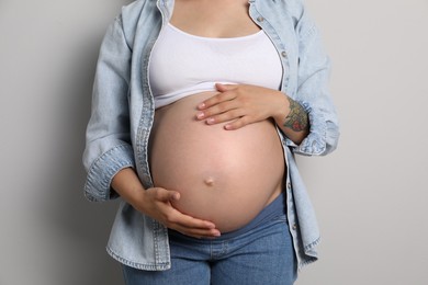 Photo of Pregnant woman on gray background, closeup view