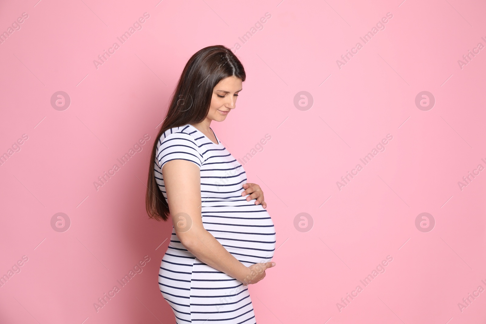 Photo of Beautiful pregnant woman on pink background, space for text