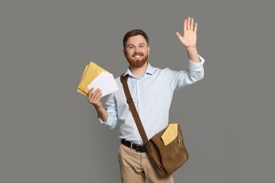 Photo of Postman with brown bag delivering letters on grey background