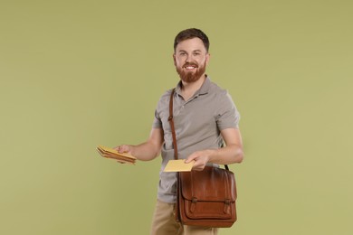 Photo of Postman with brown bag delivering letters on light green background