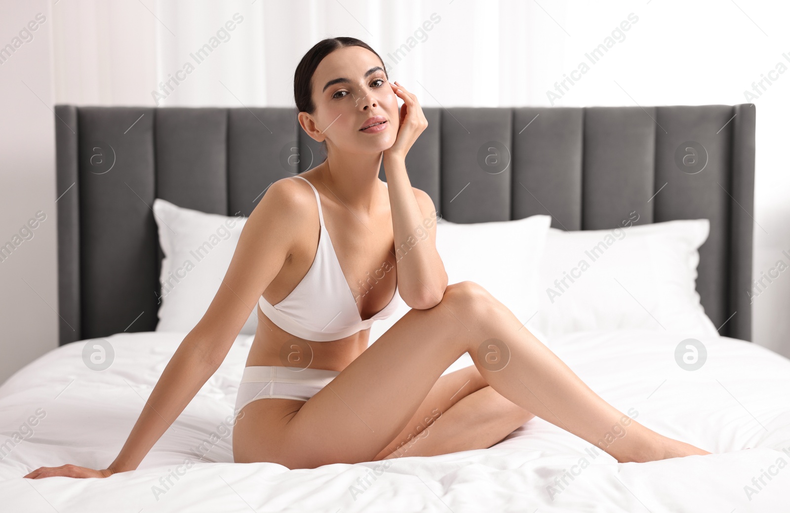 Photo of Beautiful woman with perfect skin in underwear on bed. Body care