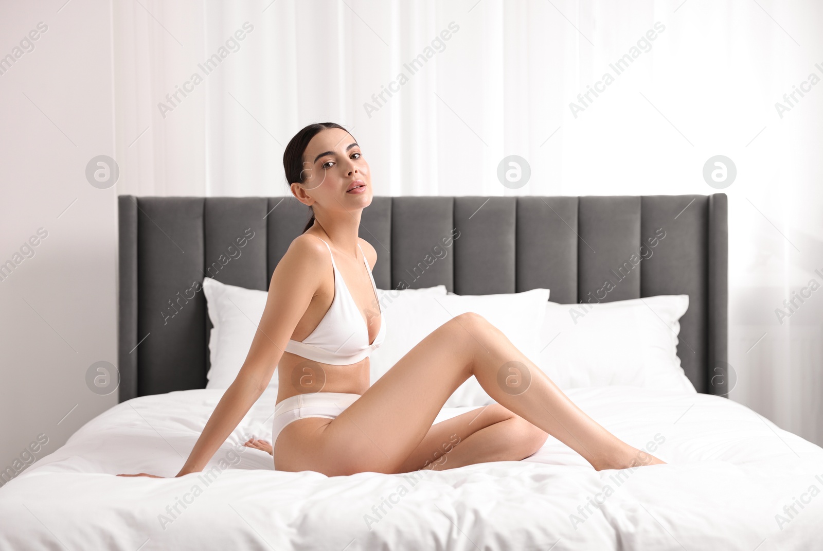 Photo of Beautiful woman with perfect skin in underwear on bed. Body care