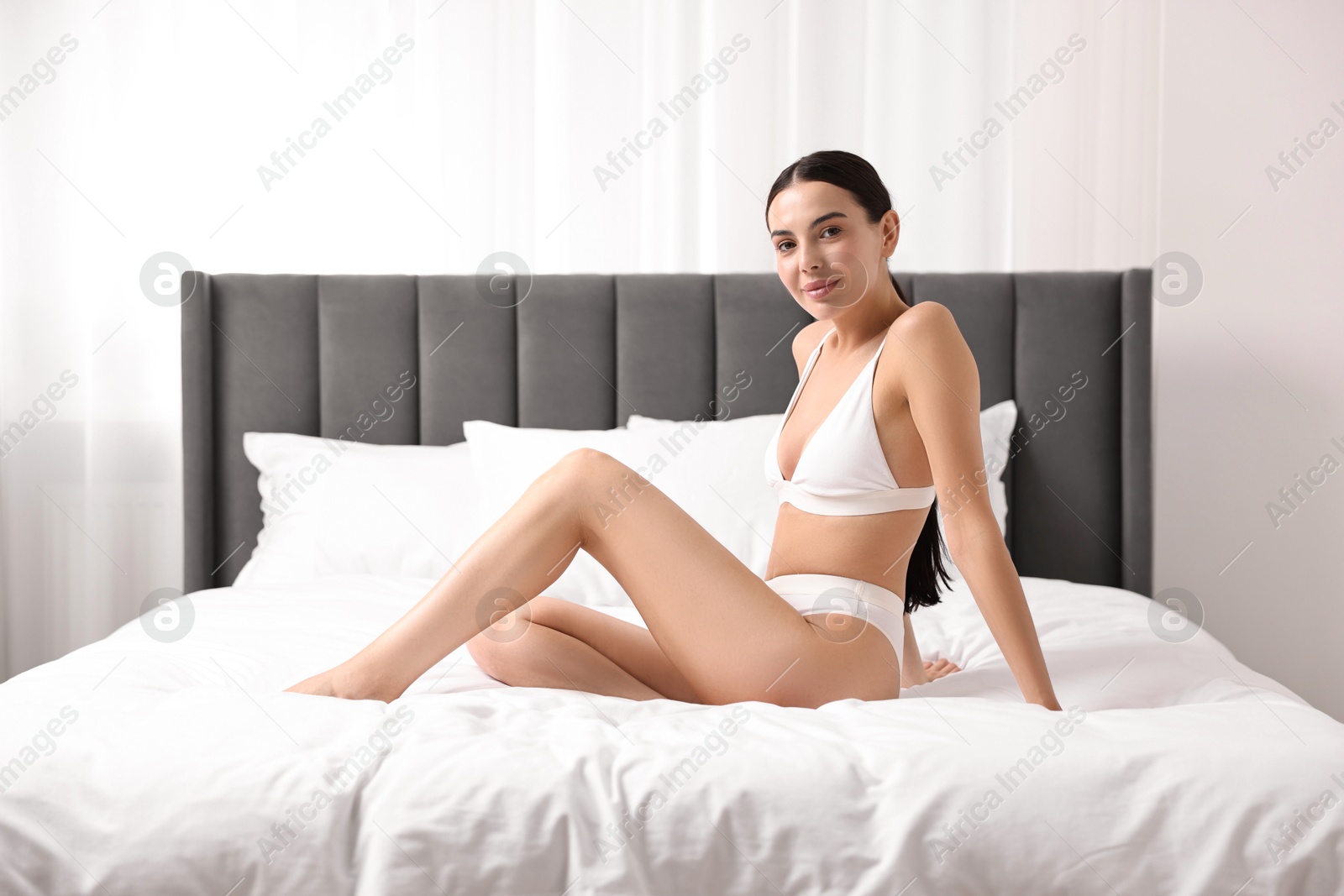 Photo of Beautiful woman with perfect skin in underwear on bed. Body care