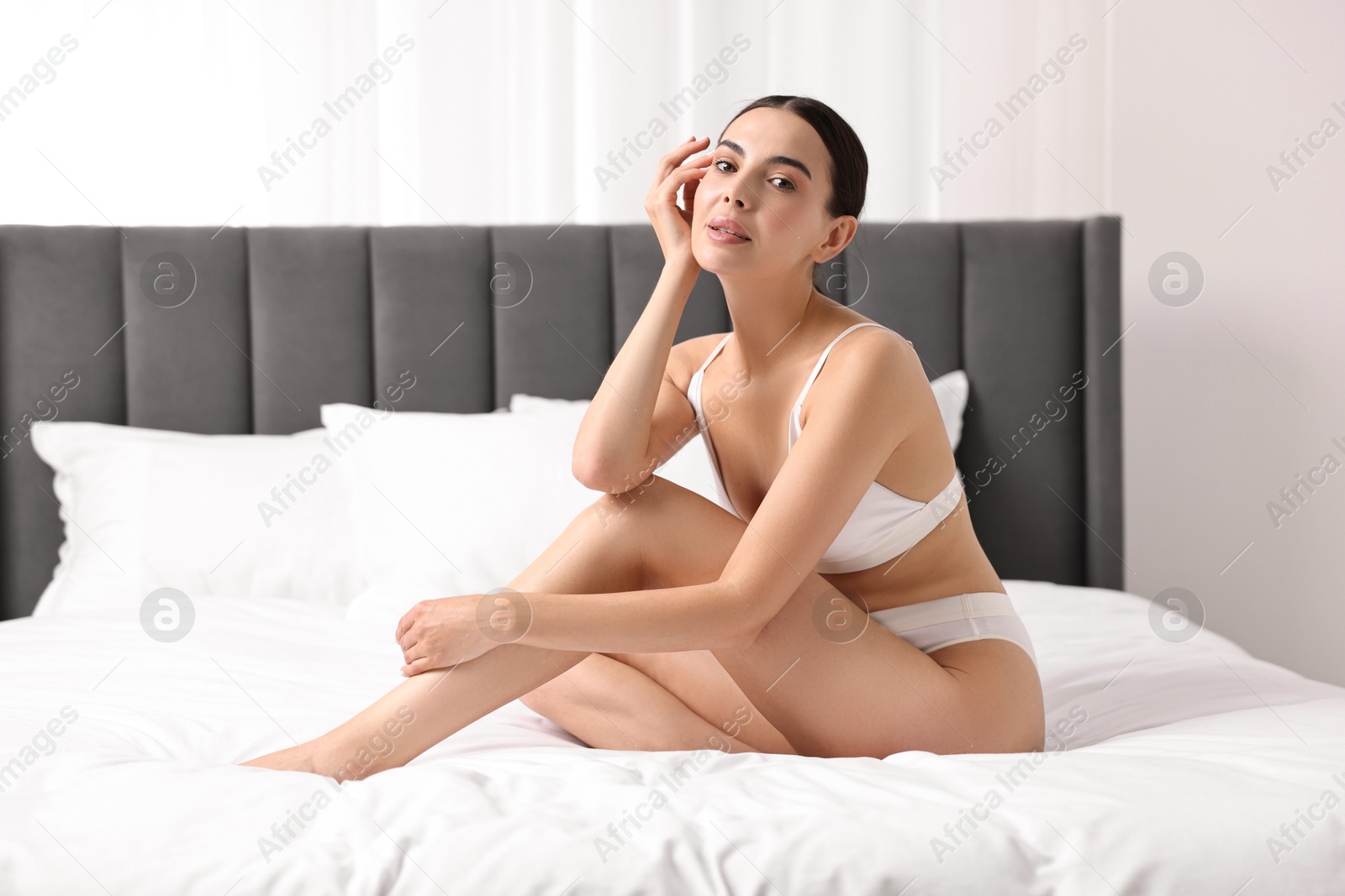 Photo of Beautiful woman with perfect skin in underwear on bed. Body care