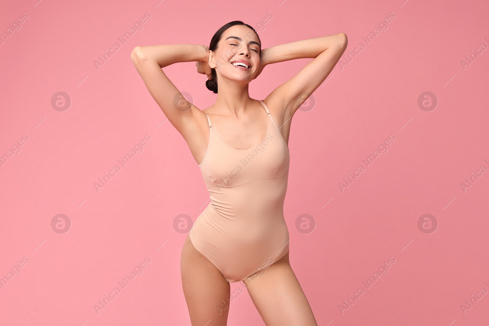 Photo of Smiling woman with perfect skin on pink background. Body care