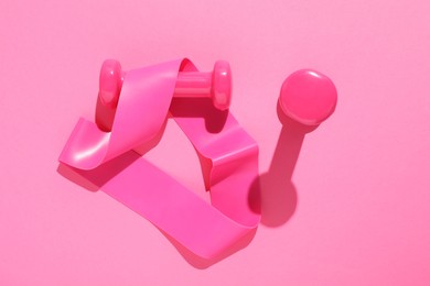 Dumbbells and fitness elastic band on pink background, flat lay