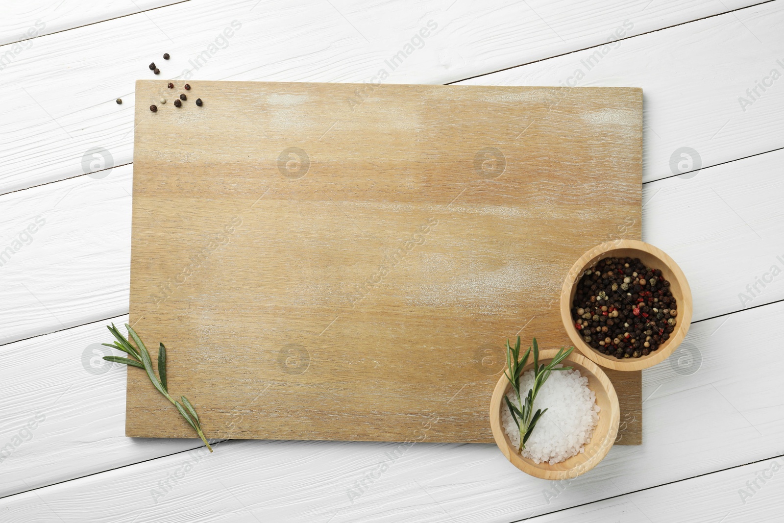 Photo of Cutting board and different spices on white wooden table, flat lay