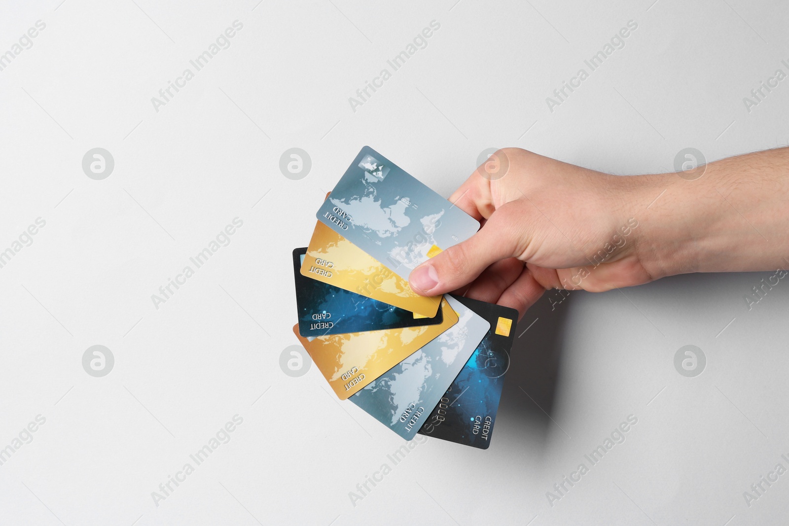 Photo of Man holding credit cards on light grey background, closeup