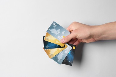 Photo of Man holding credit cards on light grey background, closeup