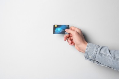 Photo of Man holding credit card on light grey background, closeup