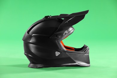 Photo of Modern motorcycle helmet with visor on light green background