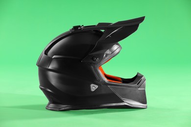 Modern motorcycle helmet with visor on light green background