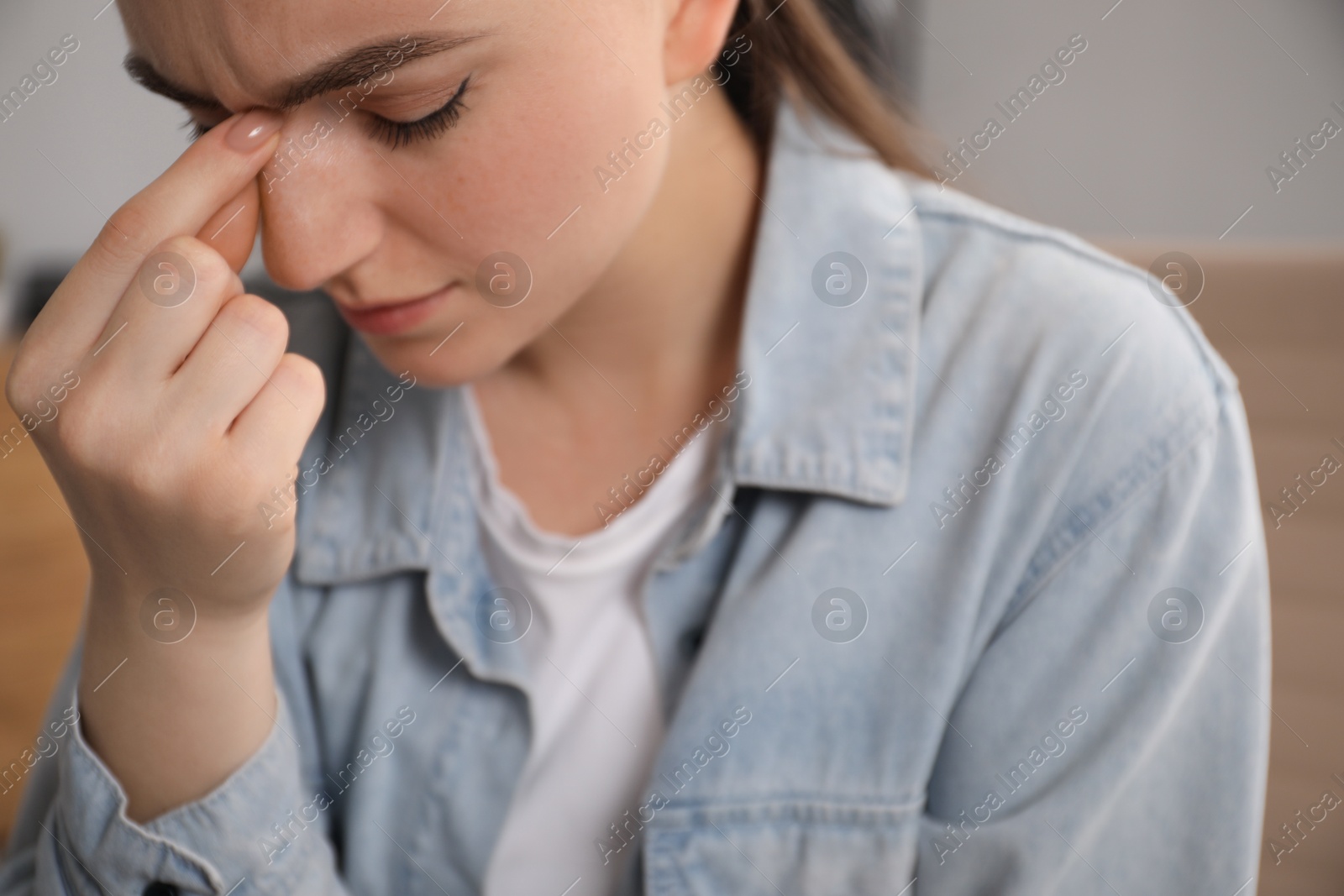 Photo of Embarrassed woman in denim jacket in office