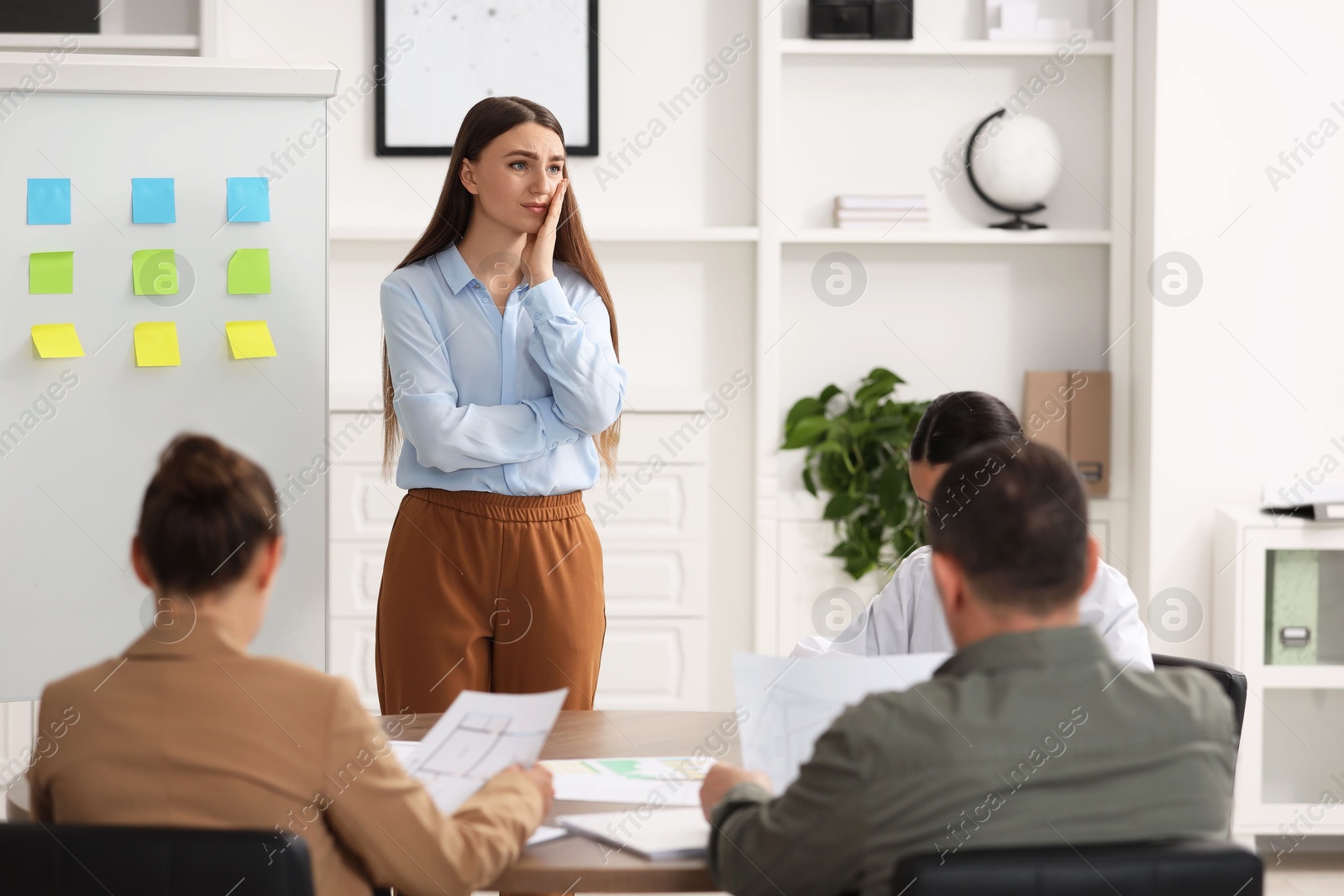 Photo of Woman feeling embarrassed during business meeting in office