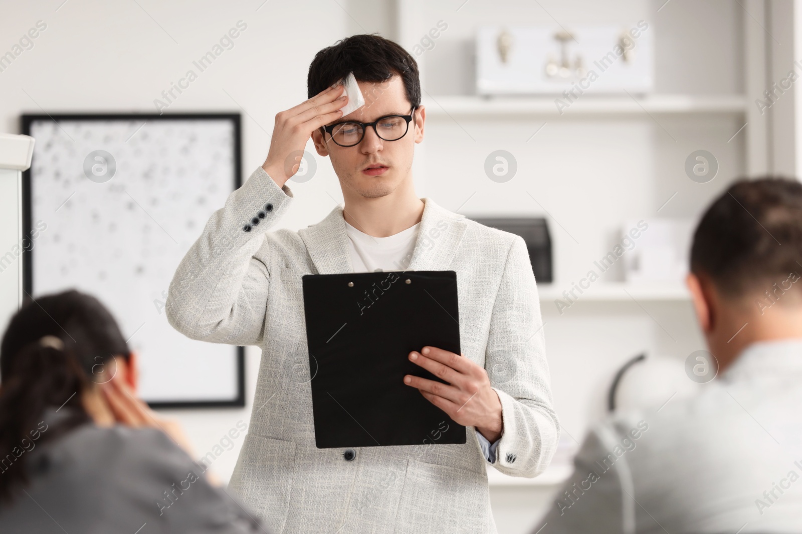 Photo of Man with clipboard feeling embarrassed during business meeting in office