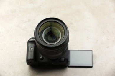 Modern photo camera on light grey table