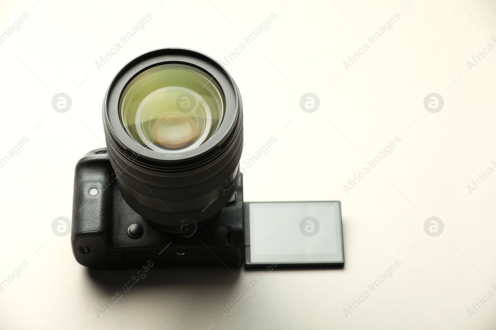 Photo of One modern photo camera on beige background, space for text