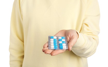 Photo of Woman holding blister with antibiotic pills on white background, closeup