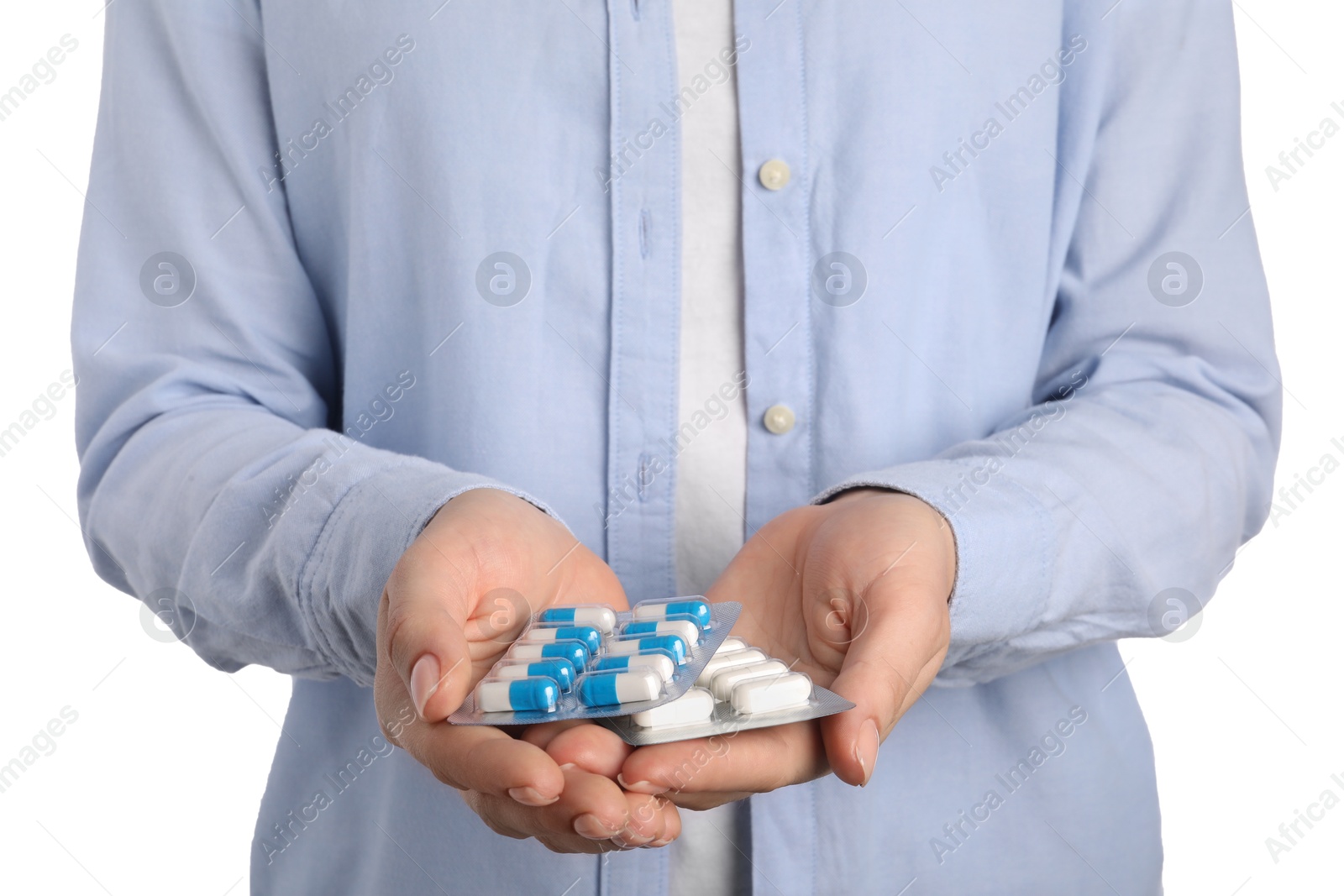 Photo of Woman holding blisters with antibiotic pills on white background, closeup