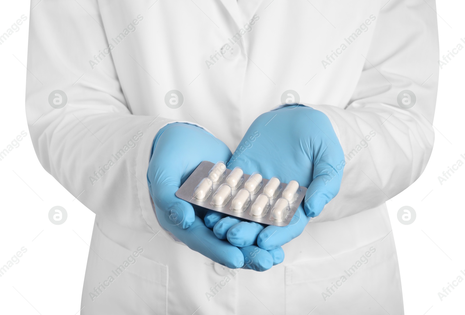 Photo of Doctor holding blister with antibiotic pills on white background, closeup