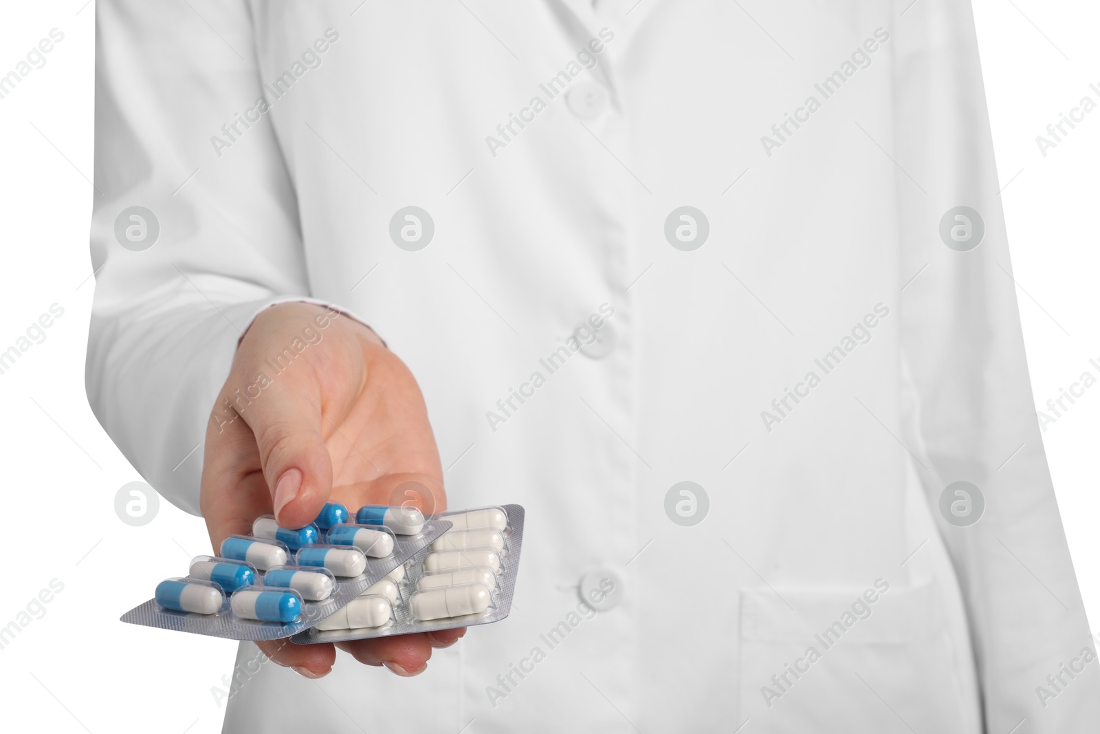 Photo of Doctor holding blisters with antibiotic pills on white background, closeup