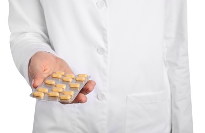 Doctor holding blister with antibiotic pills on white background, closeup