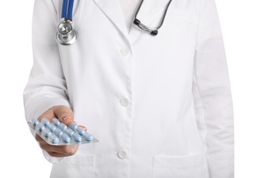 Doctor holding blister with antibiotic pills on white background, closeup