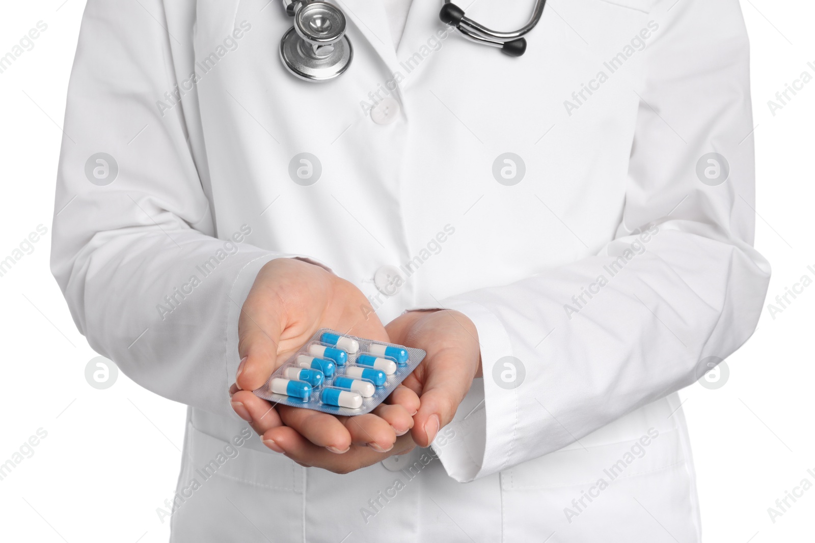 Photo of Doctor holding blister with antibiotic pills on white background, closeup