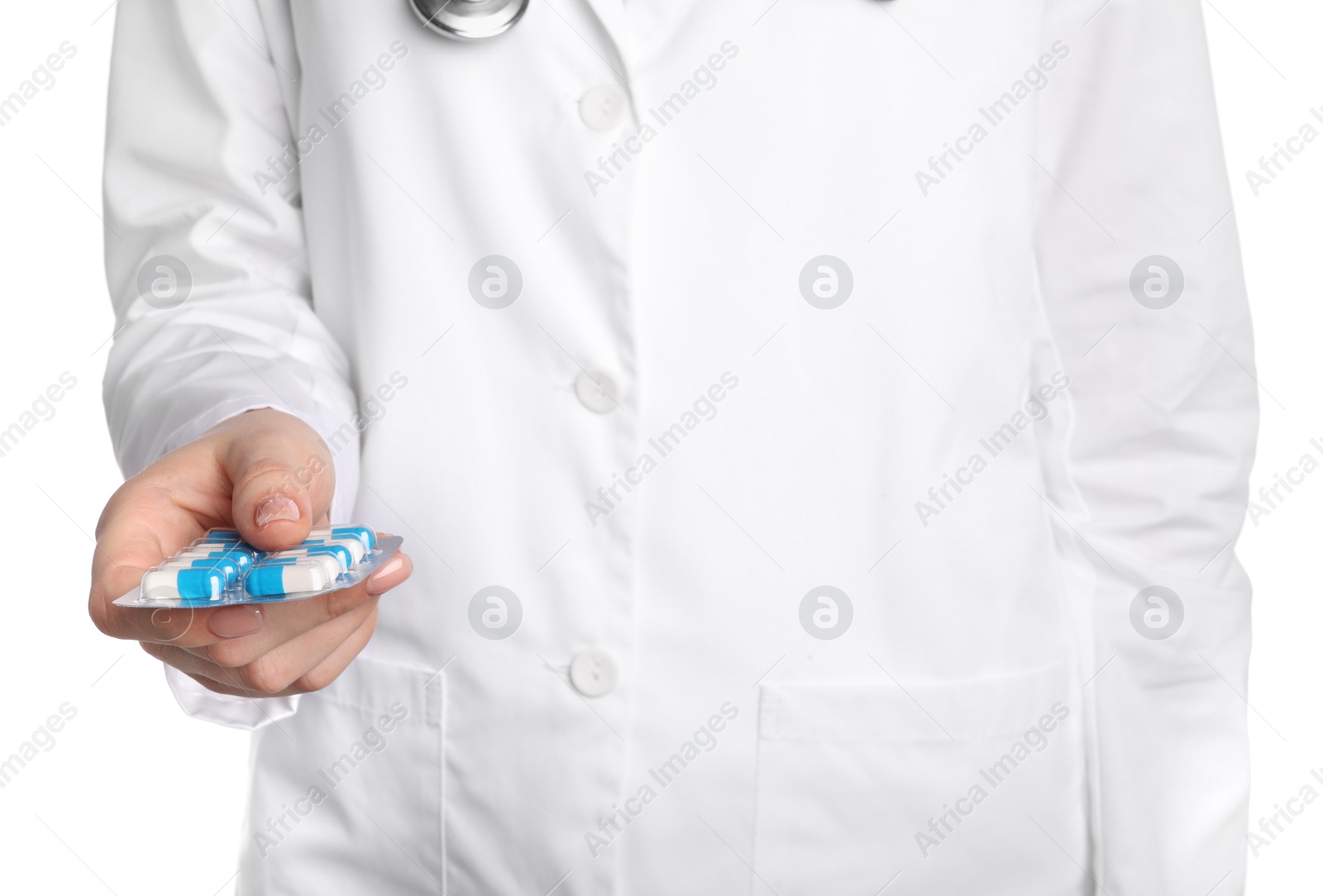 Photo of Doctor holding blister with antibiotic pills on white background, closeup