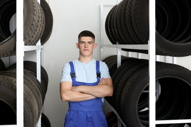 Young man near car tires in auto store