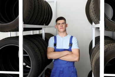 Young man near car tires in auto store