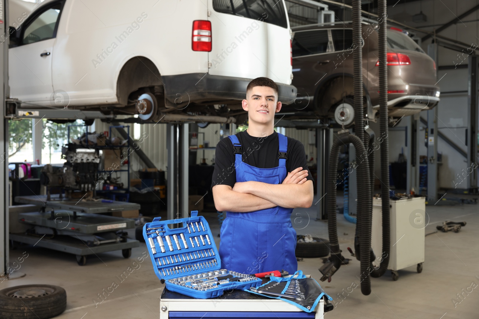 Photo of Young auto mechanic with different tools at automobile repair shop